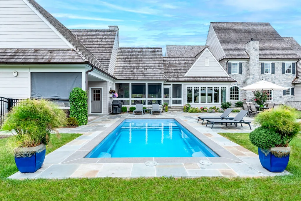 Swimming pool with surrounding backyard and deck