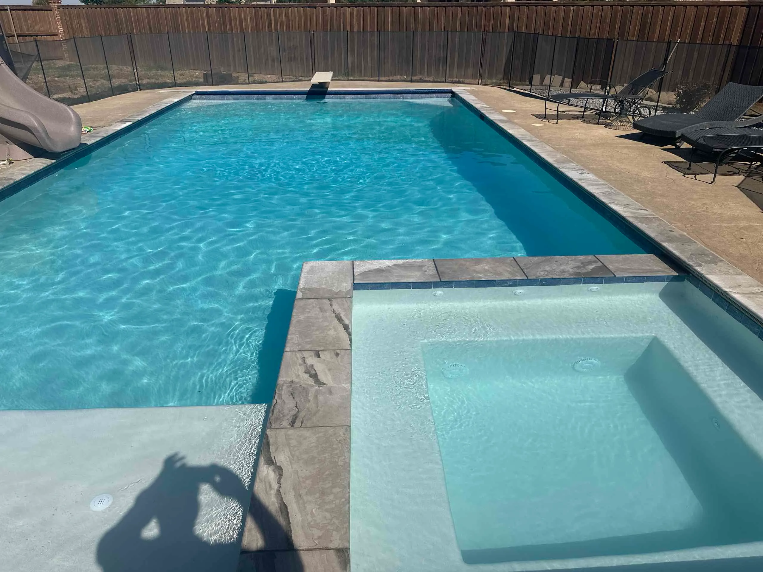 Swimming pool with surrounding backyard and deck