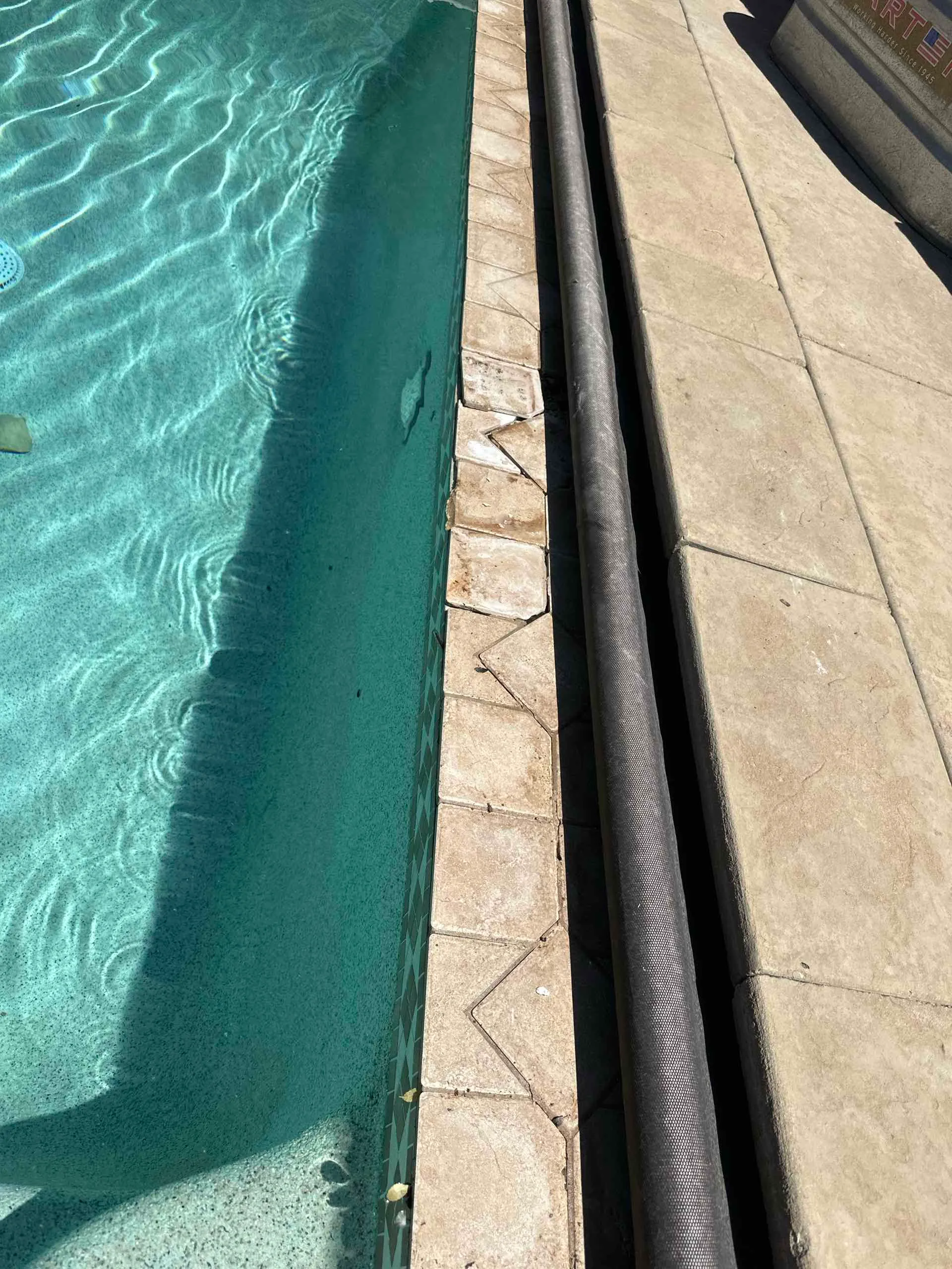 Before: Pool edge with tile, coping and pool-cover hardware