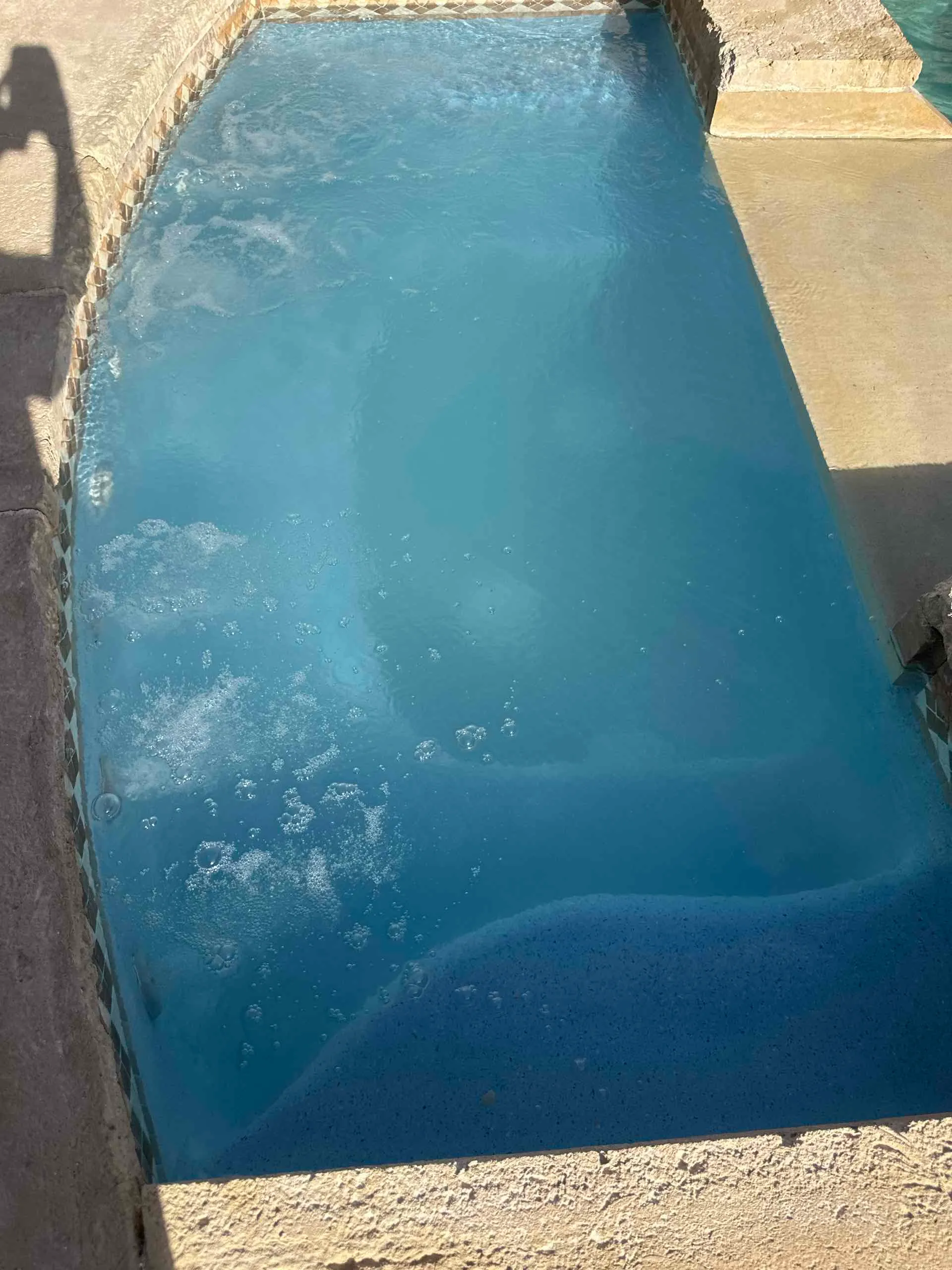 After: Rectangular spa with steps, water and a light interior finish