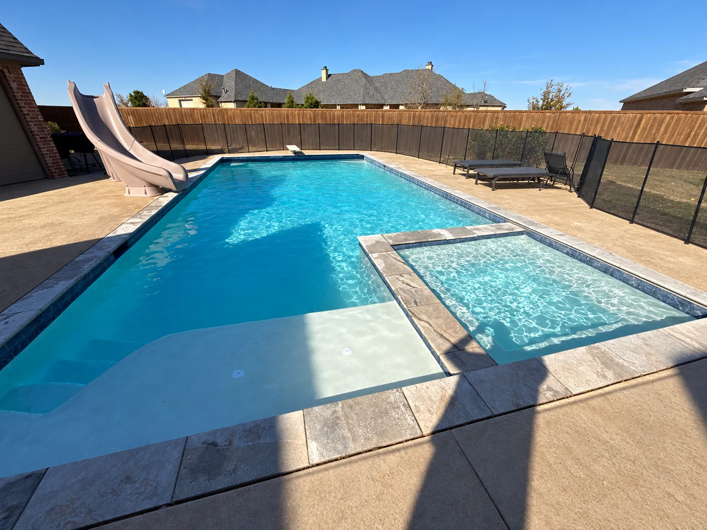Swimming pool with surrounding backyard and deck