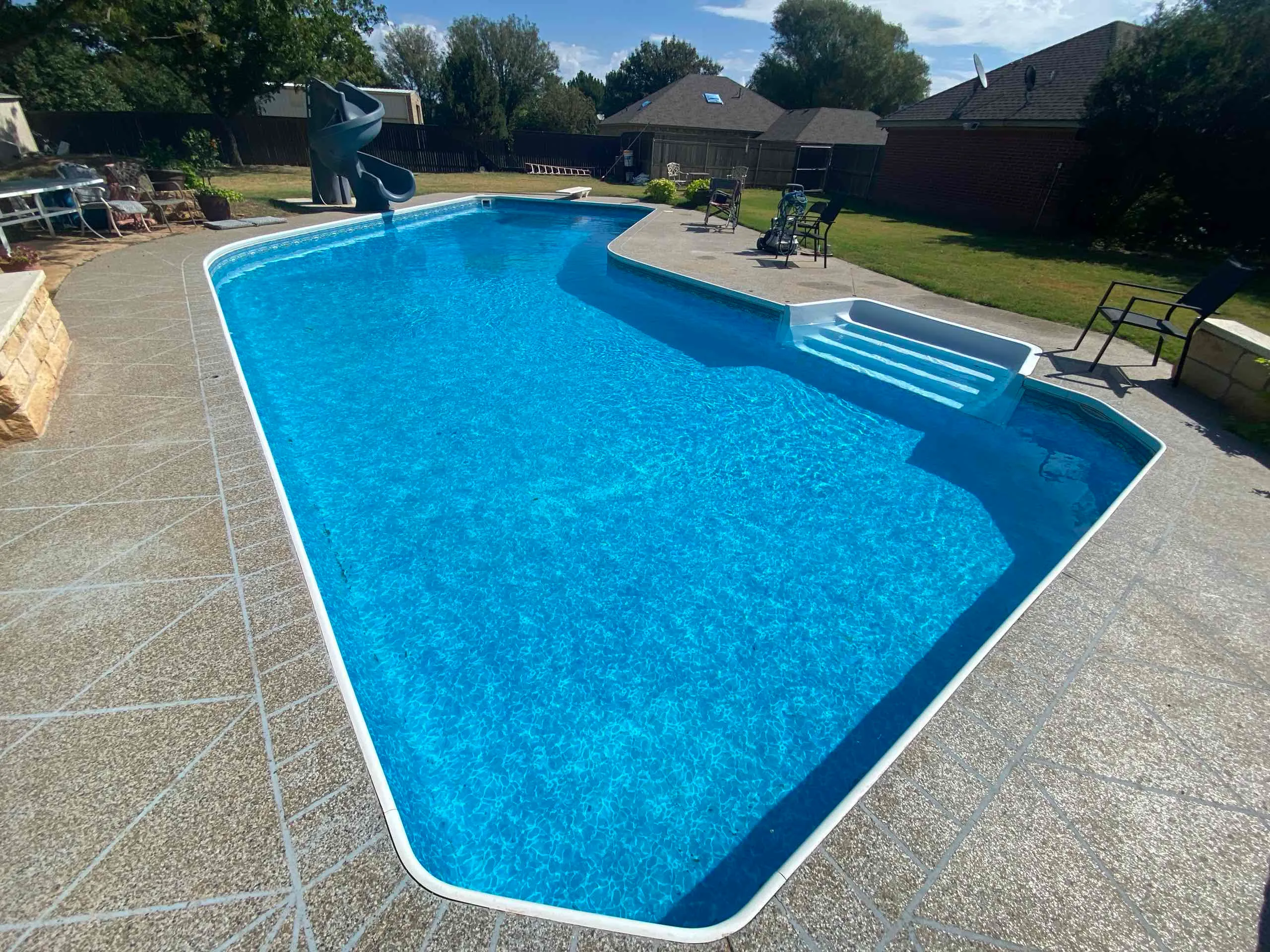 WTPP pool photograph with a curved slide, blue water and white entry steps