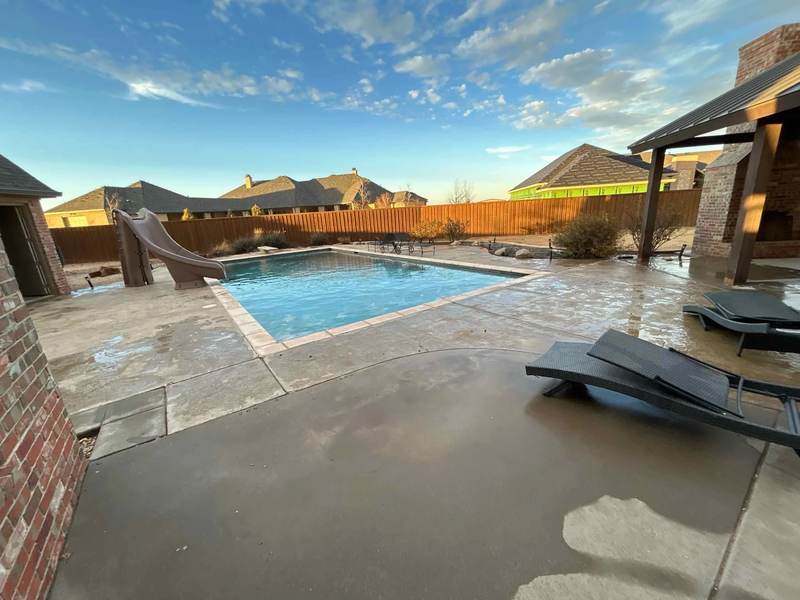 Before: Rectangular backyard pool with an attached spa and stone coping