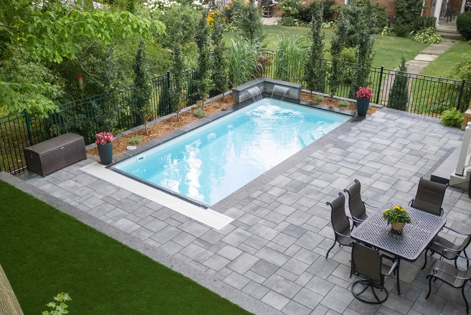 Latham Sirius rectangular pool with bench seating and a surrounding paver patio